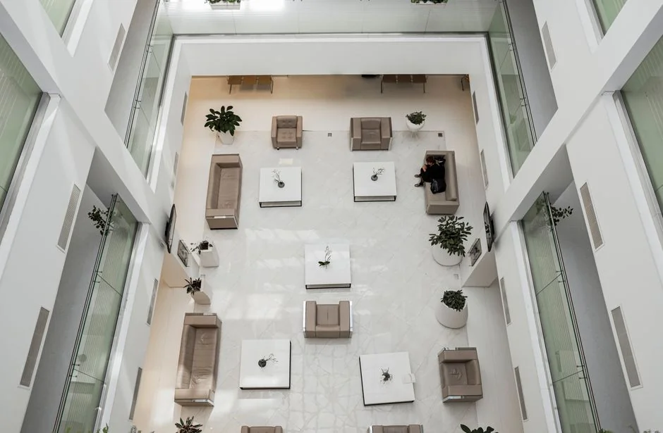 who-we-are Une personne entièrement équipée en EPI désinfecte une table à l’intérieur pour garantir l’hygiène et la sécurité.